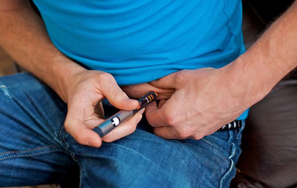 A man with diabetes injecting insulin using a pen