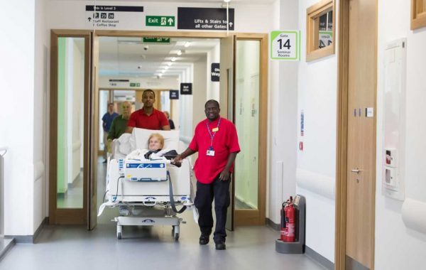 A patient being moved in her bed in a hospital