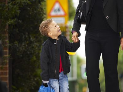 A child and an adult walking along a pavement