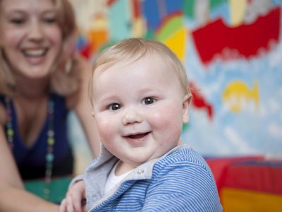 A baby boy in a creche with his mother