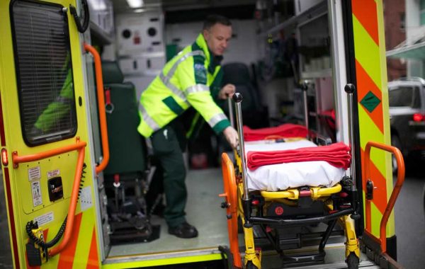 An empty trolley is wheeled onto an ambulance