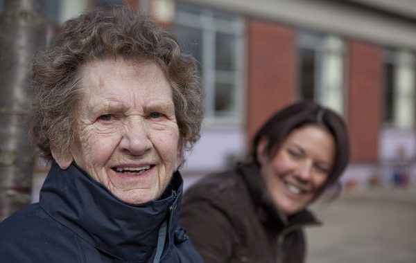 An older woman sitting on a bench with a younger woman