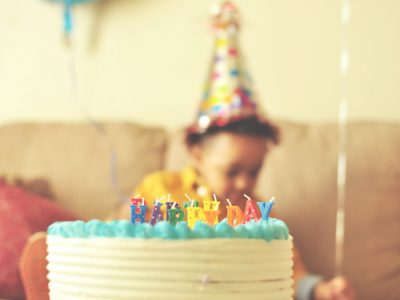 A birthday cake with a child in the background