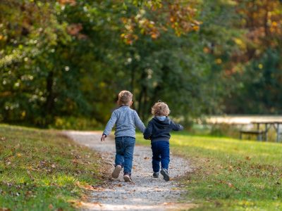 Two small children walk along a path