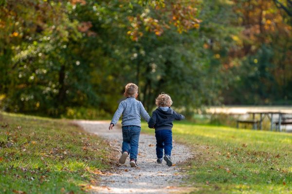Two small children walk along a path