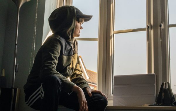 A young person looks out of a window