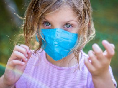 A little girl wearing a facemask