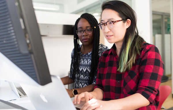 Two people investigate on a computer