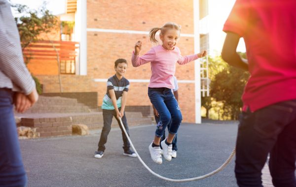 Children playing with a skipping rope in a city street
