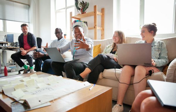 The Changing Futures team sit round a table with laptops