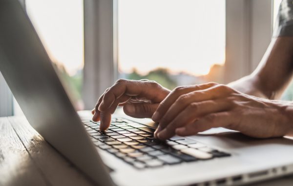 A person's hands using a laptop