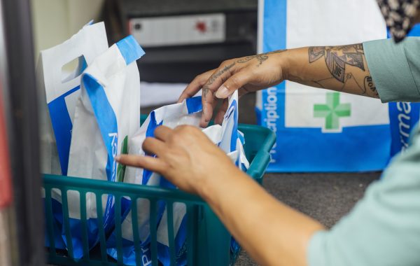 A pharmacy worker organises a basket of prescriptions