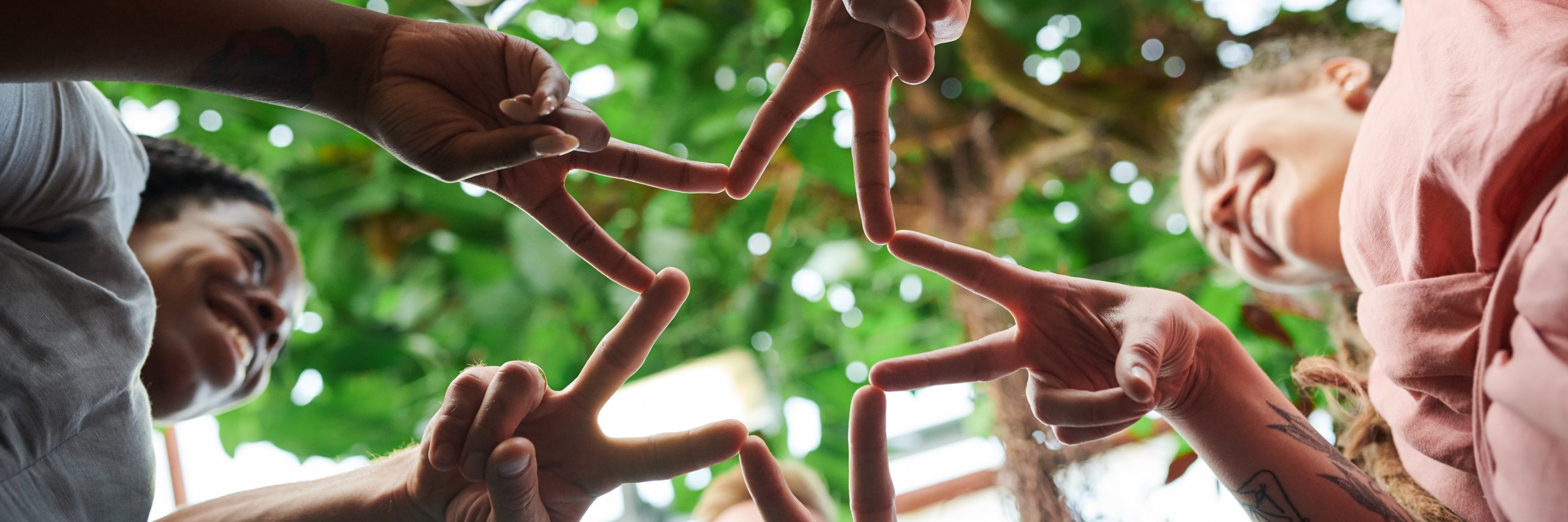 People placing their hands together forming a star shape.