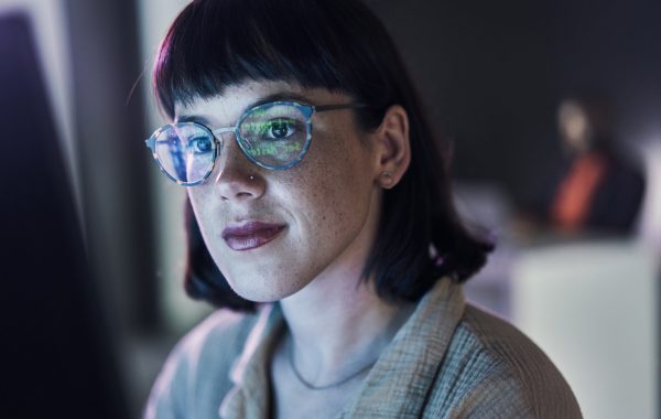 A female researcher is facing the camera as she reviews data on her computer