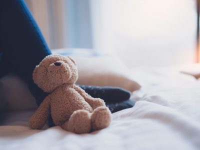 A teddy leaning against a play tent