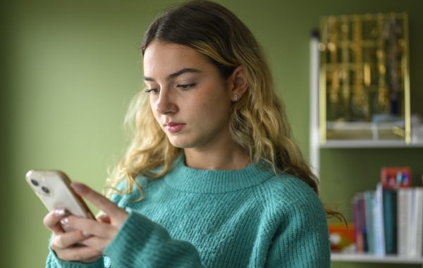 A young person using a mobile phone at home
