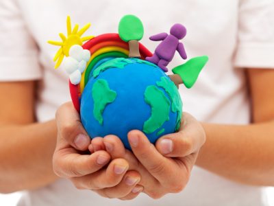 A play-doh planet earth cradled in someone's hands