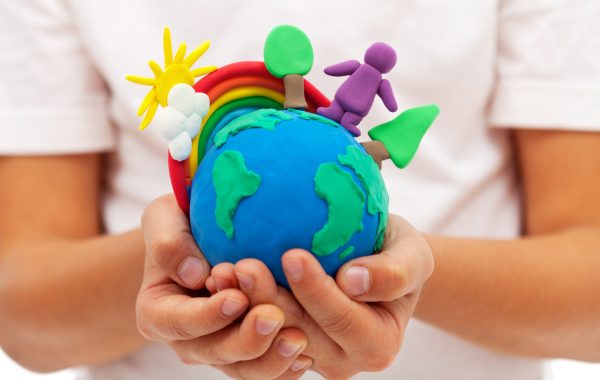 A play-doh planet earth cradled in someone's hands