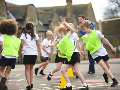 Children running around cones in a primary school playground