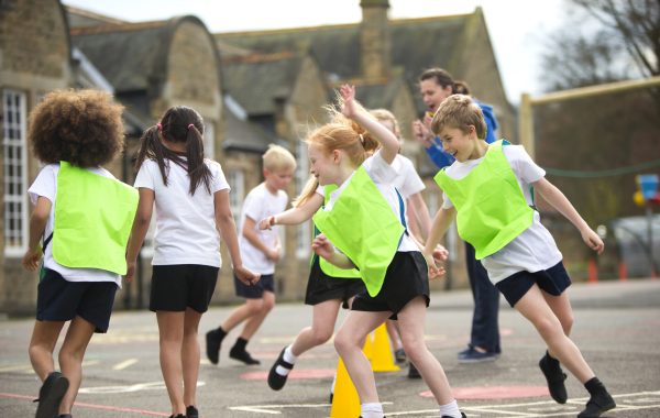 Children running around cones in a primary school playground