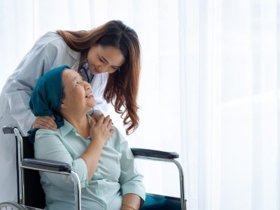 Doctor comforting a cancer patient in a wheelchair