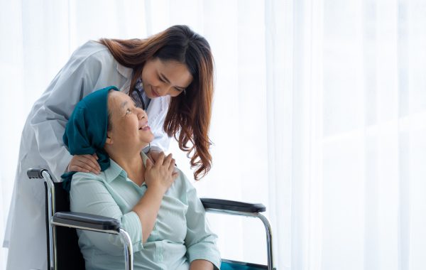 Doctor comforting a cancer patient in a wheelchair